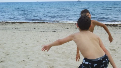 Slow motion of kids playing at the beach Stockbeeldmateriaal 113037141