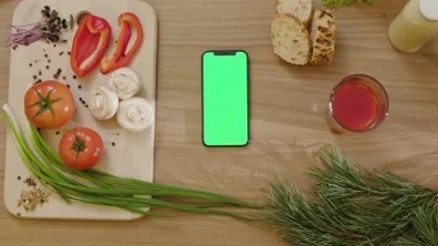 Slow motion on kitchen phone with vertical green screen on wooden tablet around Stock Footage 144962037