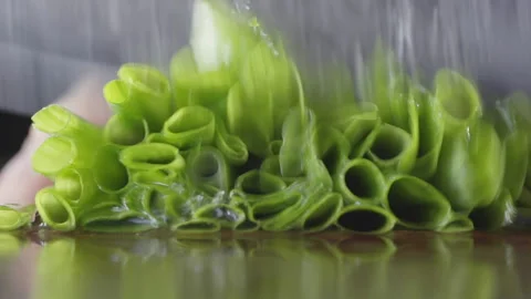 Slow motion of knife hitting chives on table with water, macro, selective focus Stock Footage 161248704