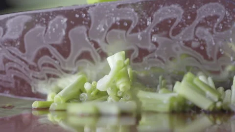 Slow motion of knife hitting chives on table with water, macro, selective focus Stock Footage 161248761