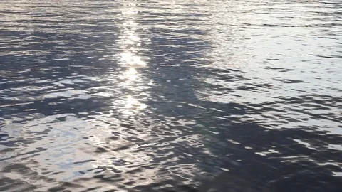 Slow motion lake water. Reflection of sparkling sunset and grey clouds. Stock Footage 79417429