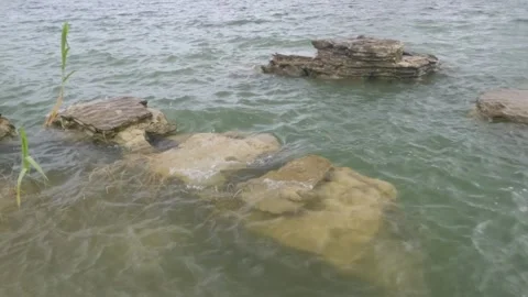 Slow motion of lake water waves hitting coral Stock Footage 307414248
