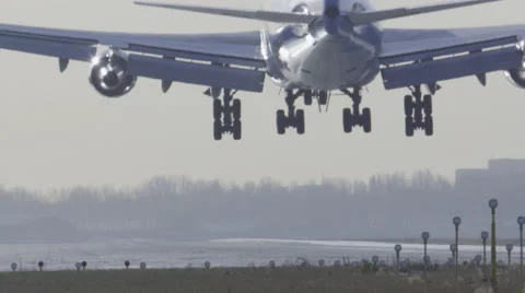 Slow motion landing touchdown of large Jumbojet from rear perspective Stock Footage 42689680