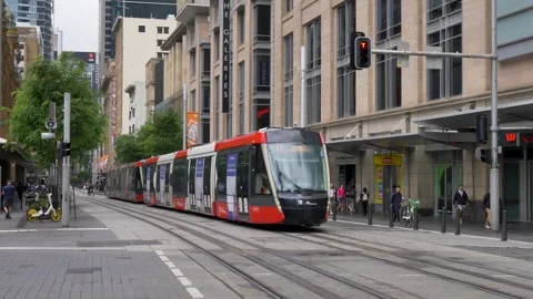 Slow motion landscape of light rail tram travelling through intersection lights Stock Footage 320522473