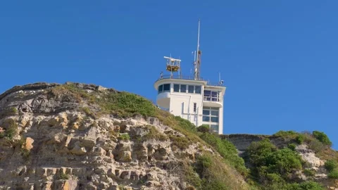 Slow motion landscape of Nobbys Head lighthouse building with navigation signal Vídeos de archivo 346107200