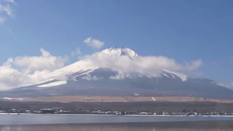Slow motion landscape of snowy Mount Fuji peak covered in foggy clouds and Stockbeeldmateriaal 335010317