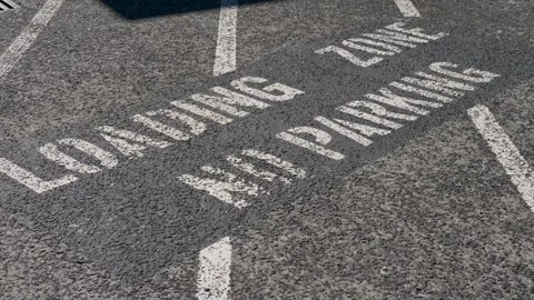 Slow motion landscape of white text lettering painted on an asphalt ground that Stock Footage 346847187