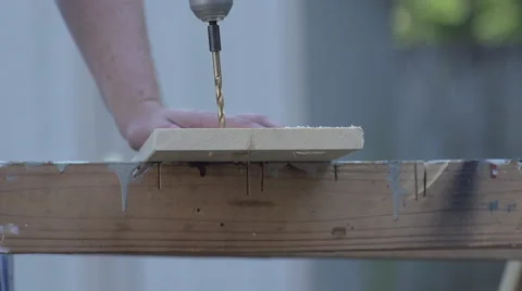 Slow Motion Large drill bit drilling through wooden board - side angle Video stock 68345611