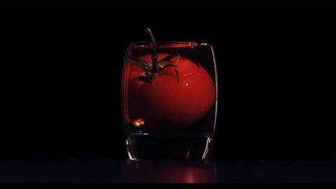 Slow motion Large tomato drops to small glass cup and splash 動画素材 150979929