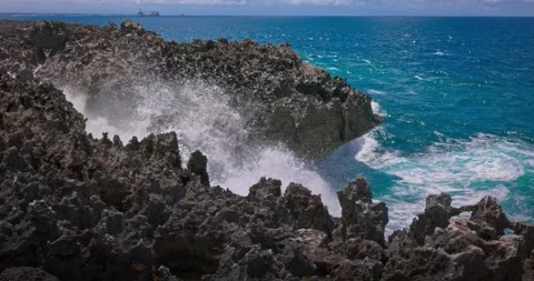Slow motion of large waves crashing against the rocks of the coastline. Stock Footage 256448910