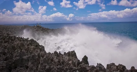 Slow motion of large waves crashing against the rocks of the coastline. Stock Footage 256449819