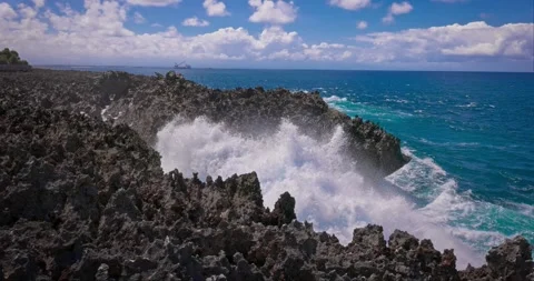 Slow motion of large waves crashing against the rocks of the coastline. Stock Footage 256450122