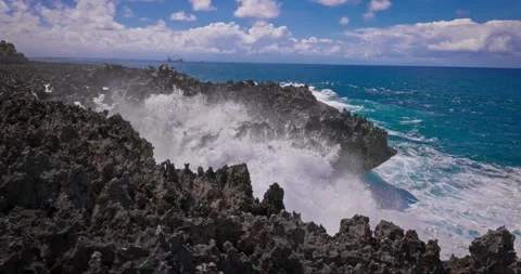 Slow motion of large waves crashing against the rocks of the coastline. Stock Footage 256450219