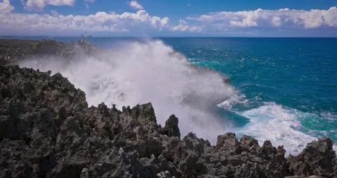 Slow motion of large waves crashing against the rocks of the coastline. Stock Footage 256450388