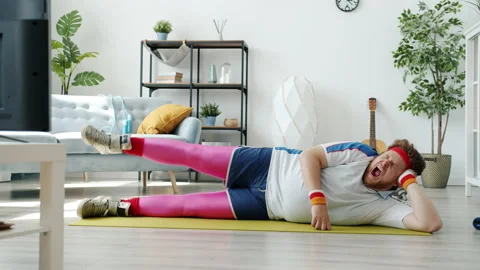 Slow motion of lazy man training on fitness mat then yawning and sleeping during Stock Footage 156528613