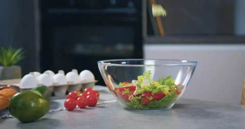 Slow motion of leaves of lettuce which is falling into bowl with tomatoes on Stock Footage 148745799