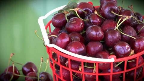 Slow motion left of cherry in a red plastic basket Stock Footage 76974578