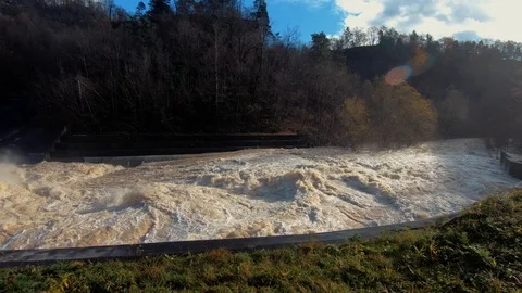 Slow motion left pan flood water leaving dam and spills in river canal Stock Footage 121679637