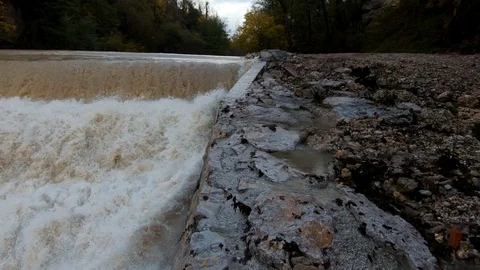 Slow motion left pan rapid brown river water on man made cascades Stock-Footage 120456808