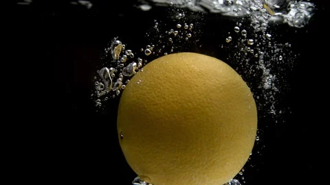 Slow Motion of a Lemon Falling Into a Pool of Water with a Black Backdrop Stock Footage 270408652