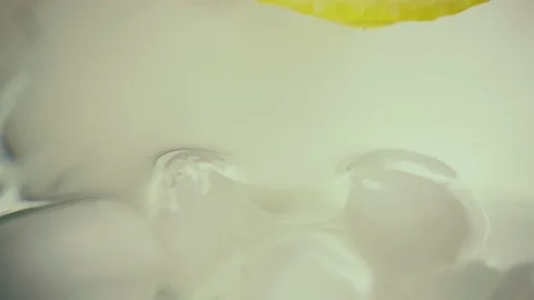 Slow motion. Lemon slice slowly descends into ice Stock Footage 75567865