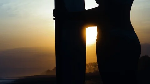 SLOW MOTION Lens flare between a woman and surfboard shot at sunset in Indonesia Stock Footage 123609808