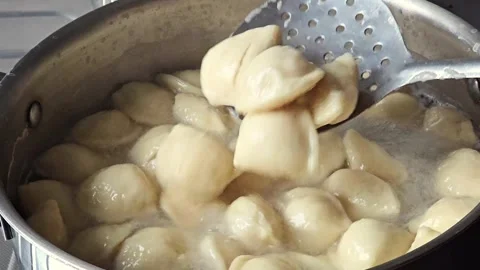 Slow Motion of Lifting Ready Dumplings with a Slotted Spoon from Boiling Wate 動画素材 345454096
