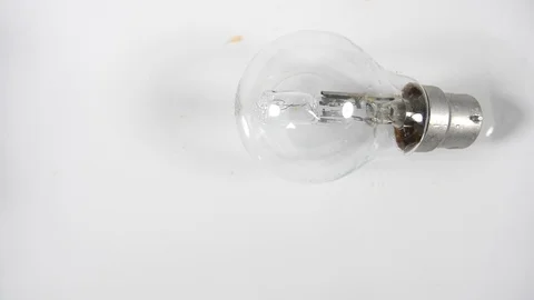 Slow motion light bulb rolling on white  background, tungsten electric lamp Stock Footage 88340882