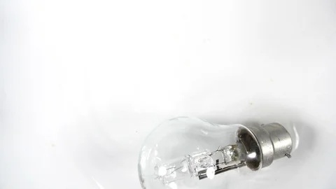 Slow motion light bulb rolling on white  background, tungsten electric energy Stock Footage 88340885