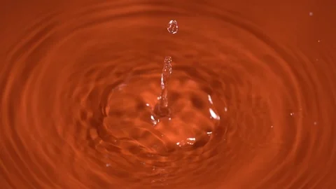Slow motion liquid splash on orange background Stock Footage 336443036