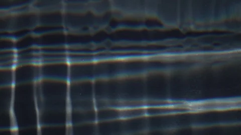 Slow motion of liquid web pattern of refracted and reflected sun shine Stock Footage 99145046