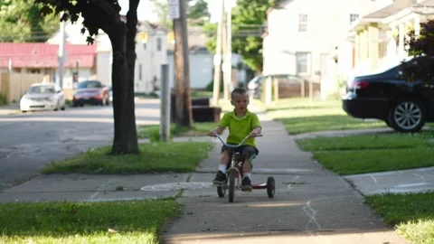 Slow Motion of Little Boy Accelerating on His Tricycle Stock Footage 133652487