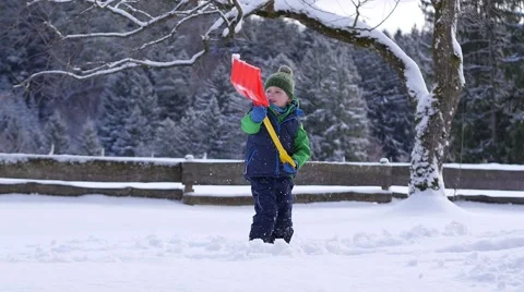 Slow motion of a little boy throwing snow with a snow shovel 動画素材 46425540
