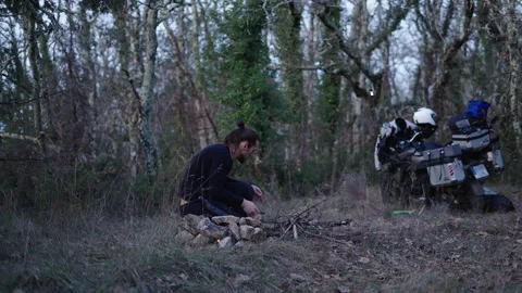 Slow motion Lonely young boy lighting dry branches with a flint to make a Stock Footage 274740182