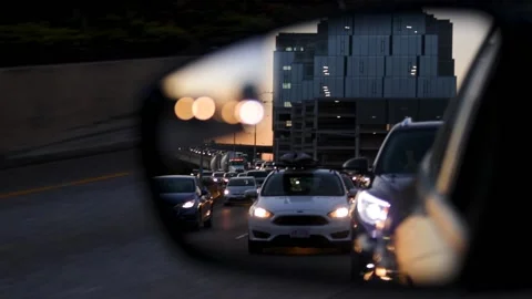 Slow motion looking back at driver's side car mirror in traffic at rush hour. Stock-Footage 163489501