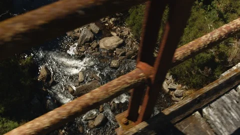 Slow motion looking down at river through bridge rails Stock Footage 88380828