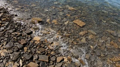 Slow motion looking down sea waves fall on the pebble beach Stock Footage 130074194
