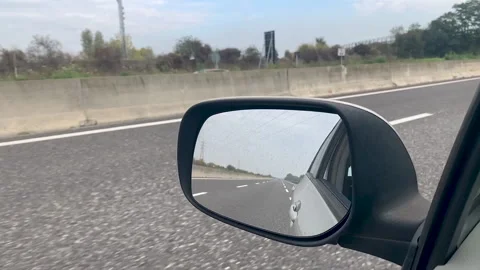 Slow motion - Looking at the reflection in the car rear mirror while driving Vídeo Stock 142081503