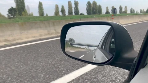 Slow motion - Looking at the reflection in the car rear mirror while driving Vídeos de archivo 142083734
