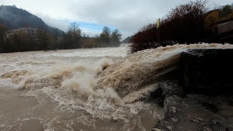 Slow motion low angle flooding dirty turbulent water flowing over spillway Stock Footage 120528839