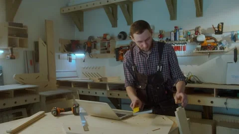 SLOW MOTION, LOW ANGLE, LENS : Carpenter measures a plank and compares Stock Footage 150817260