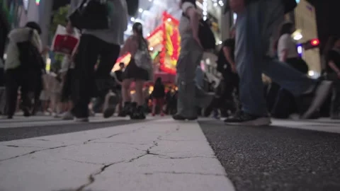 Slow motion low angle people cross road at night Stock Footage 276760394