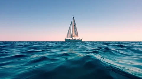 Slow motion low angle sea level view of yacht sailing at sunset Vídeo Stock 279904549
