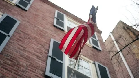 Slow motion low angle shot of a Betsy Ross flag on a house in Philadelphia Stock Footage 138655832