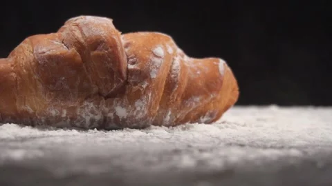 Slow motion low angle shot of croissant dropped on pile of flour 库存影片 278200138
