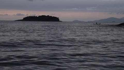 Slow Motion Low Angle Shot of a Fisherman in a Canoe at Dawn in Paraty Bay Stock Footage 320634993