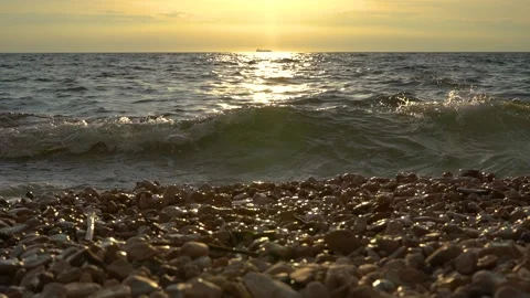 Slow motion low angle view of waves hitting gravel shore Stock Footage 157383452