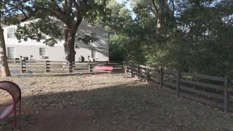 Slow motion low drone drift through empty dog park at golden hour Stock Footage 346731999