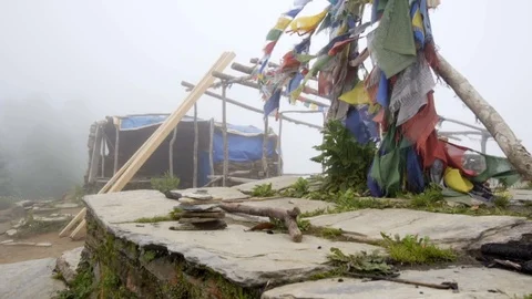 Slow motion low to high of prayer flags in Nepal and house construction Stock Footage 91434331