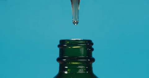 Slow motion of macro close up of droplet dosing oil from a jar. Stock Footage 116605959
